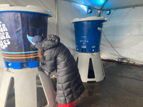 A woman fills her water bottle at a Zero Waste water station