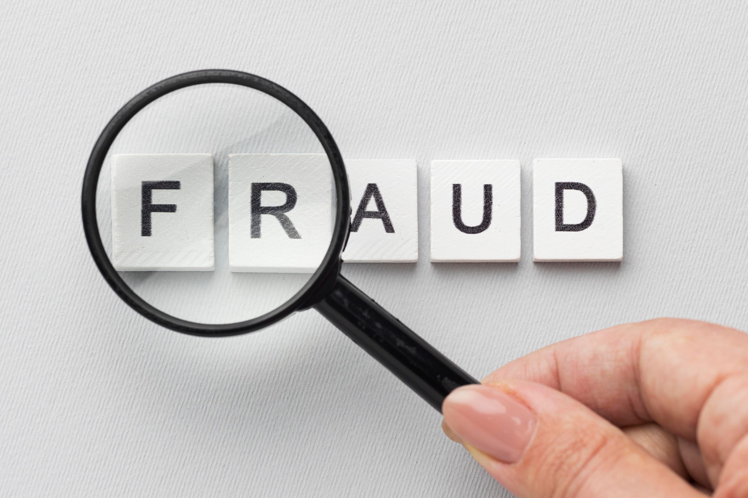Fraud sign with magnifying glass